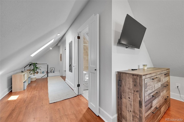 1208 S Pennsylvania St, Denver, CO 80210 - corridor with light wood finished floors, vaulted ceiling, baseboards, and a skylight