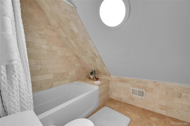 1208 S Pennsylvania St, Denver, CO 80210 - bathroom featuring toilet, shower / tub combo with curtain, lofted ceiling, and tile walls