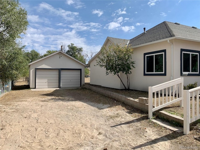 view of side of property with a garage and an outbuilding