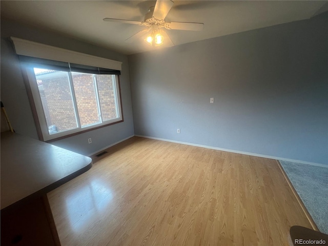 unfurnished room with light wood-type flooring and ceiling fan