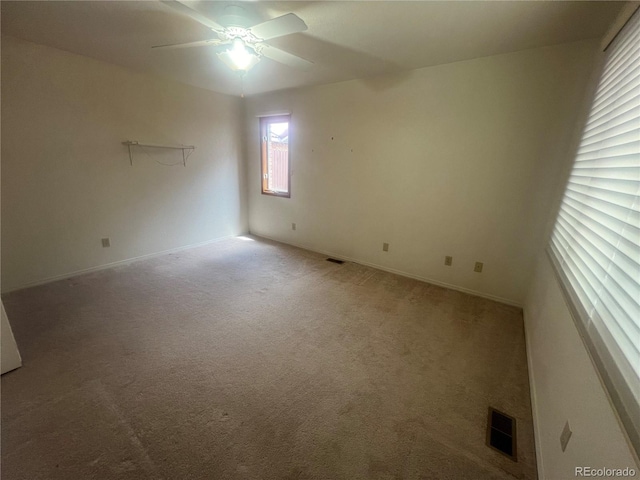 carpeted spare room featuring ceiling fan