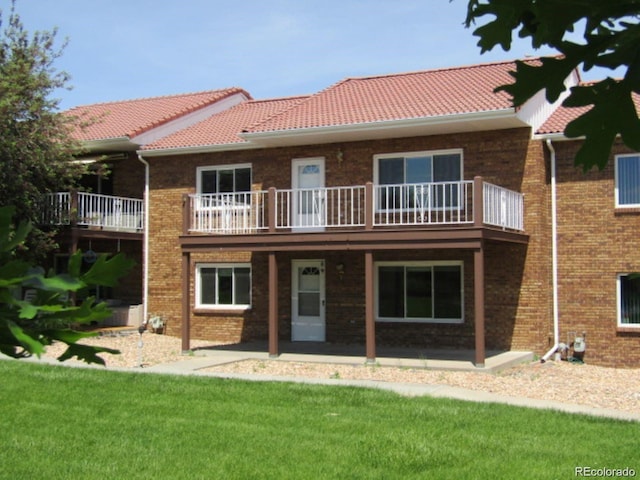 127 Fairway Ln, Fort Morgan, CO 80701 - back of property featuring a patio area, brick siding, a tiled roof, and a lawn