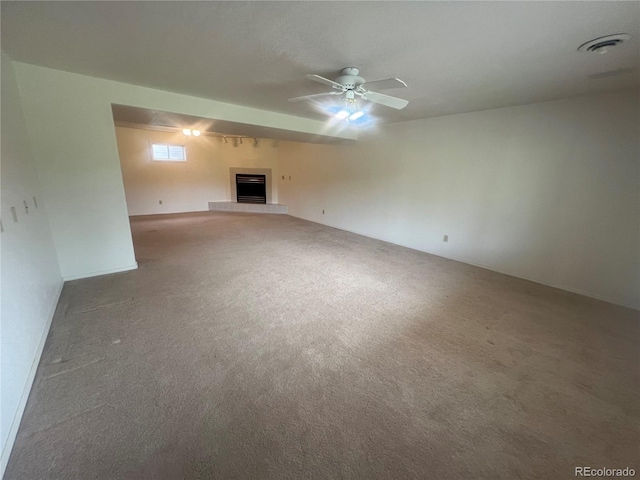 127 Fairway Ln, Fort Morgan, CO 80701 - unfurnished living room featuring a fireplace with raised hearth, visible vents, a ceiling fan, and carpet floors