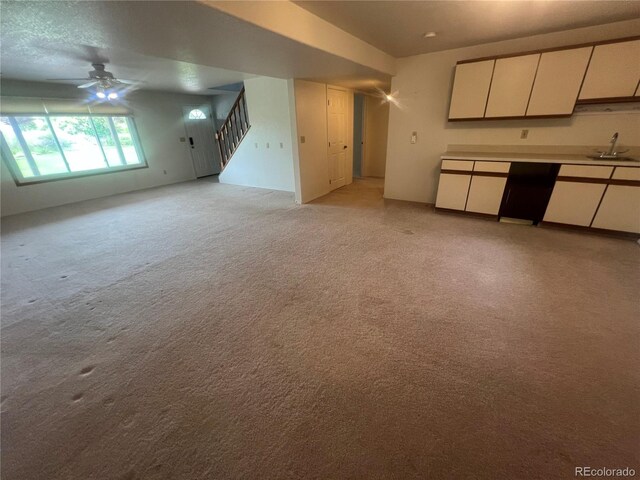 127 Fairway Ln, Fort Morgan, CO 80701 - unfurnished living room with a sink, a ceiling fan, light colored carpet, and stairs