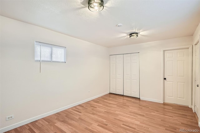 unfurnished bedroom featuring light wood-type flooring and a closet