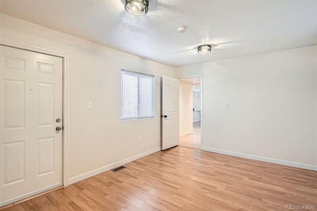 entryway with light hardwood / wood-style flooring and a textured ceiling