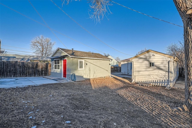 rear view of property with a patio area and an outbuilding