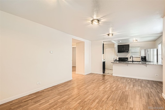 unfurnished living room featuring sink and light wood-type flooring