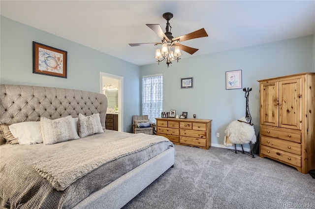 bedroom with ceiling fan, light colored carpet, and ensuite bath