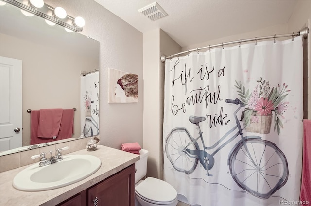 bathroom with vanity, a shower with shower curtain, and toilet