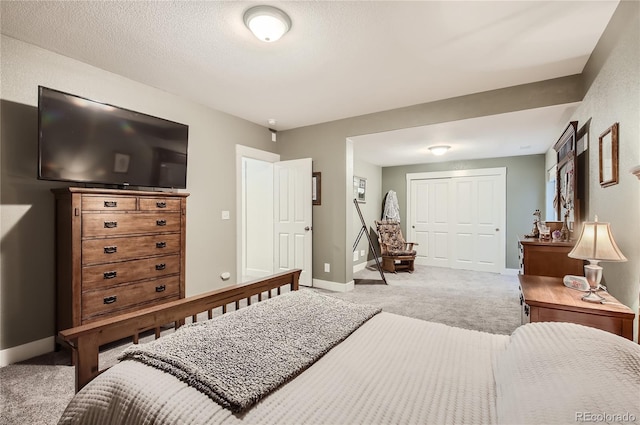 bedroom with a closet, a textured ceiling, and carpet