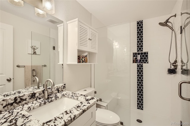 bathroom featuring vanity, an enclosed shower, and toilet