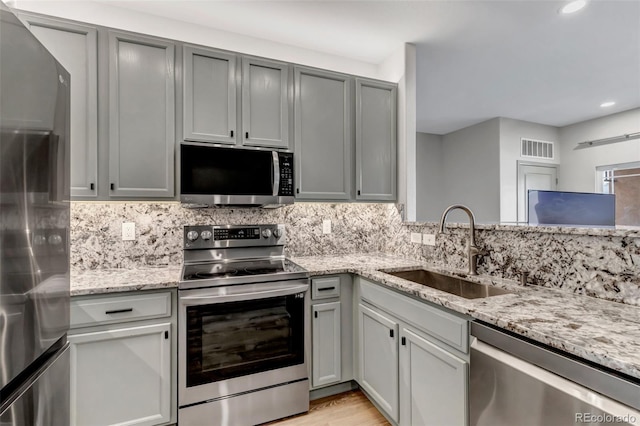 837 E 98th Ave Unit 403, Thornton, CO 80229 - kitchen featuring appliances with stainless steel finishes, a sink, recessed lighting, light stone counters, and decorative backsplash