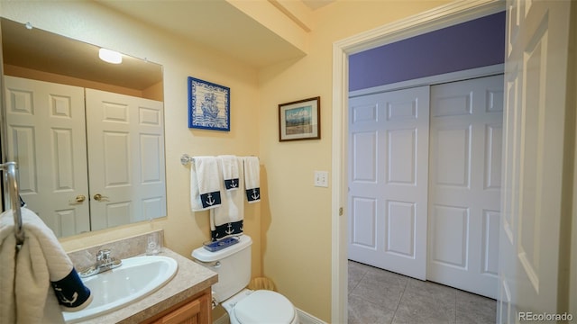 bathroom featuring tile patterned floors, toilet, baseboards, and vanity