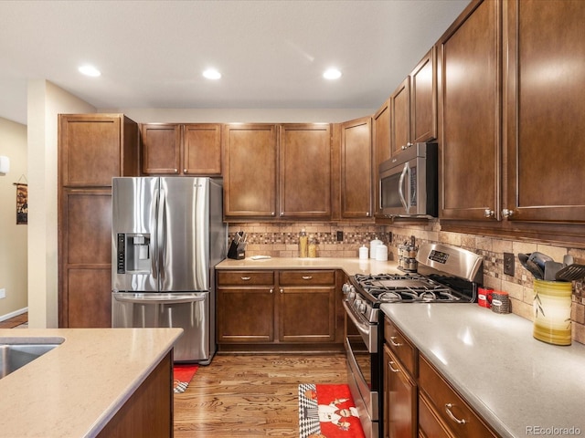 569 Jackson St, Lafayette, CO 80026 - kitchen with stainless steel appliances, light wood-style flooring, backsplash, and recessed lighting