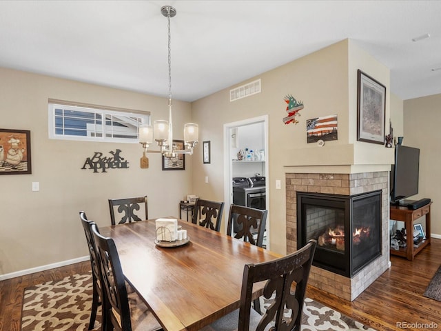 569 Jackson St, Lafayette, CO 80026 - dining room with washing machine and dryer, wood finished floors, and a brick fireplace