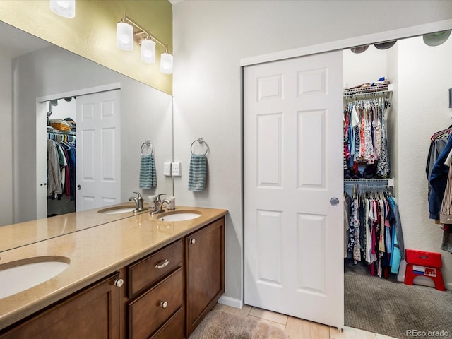569 Jackson St, Lafayette, CO 80026 - bathroom featuring double vanity, a spacious closet, and tile patterned flooring