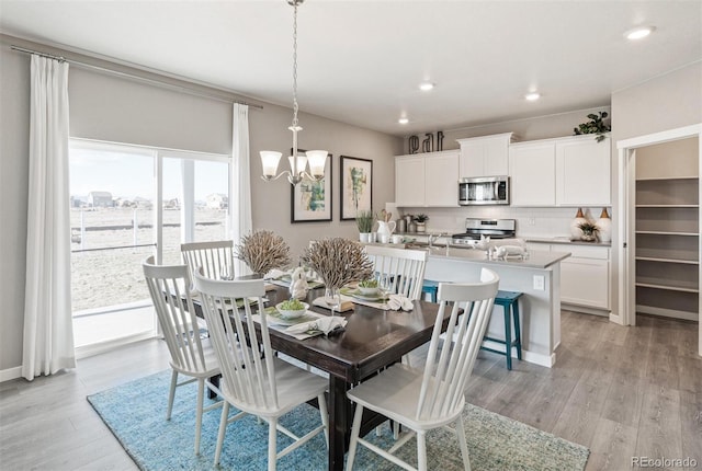 dining space featuring light hardwood / wood-style floors and an inviting chandelier