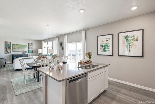 kitchen with pendant lighting, white cabinets, sink, a kitchen island with sink, and stainless steel dishwasher