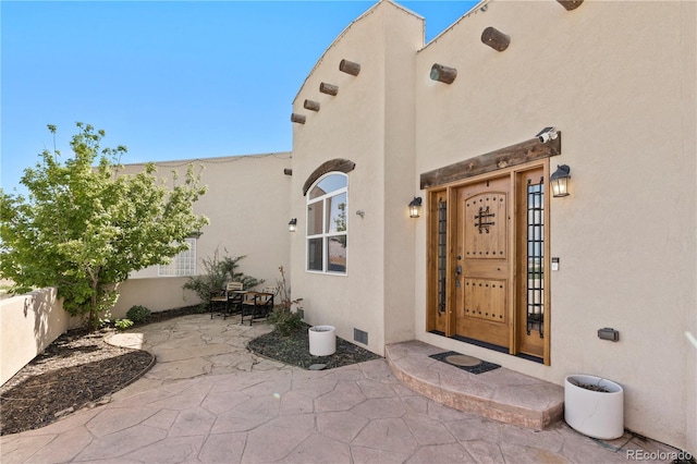 view of exterior entry with a patio