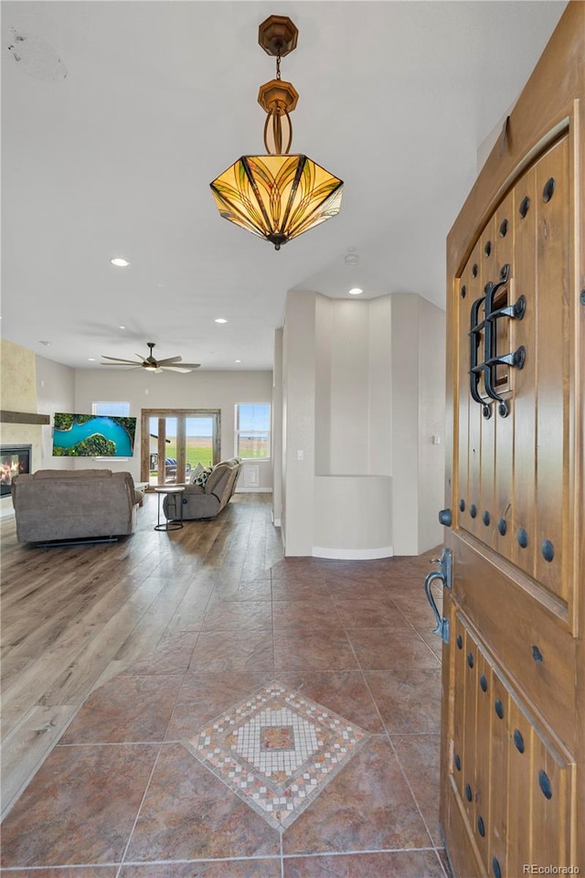 foyer featuring a fireplace, hardwood / wood-style floors, and ceiling fan