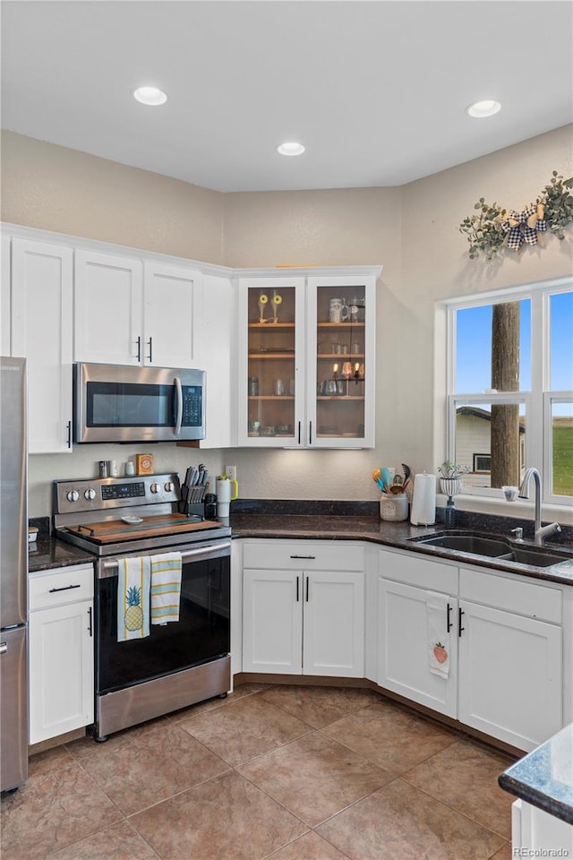 kitchen with white cabinets, dark stone countertops, sink, and appliances with stainless steel finishes