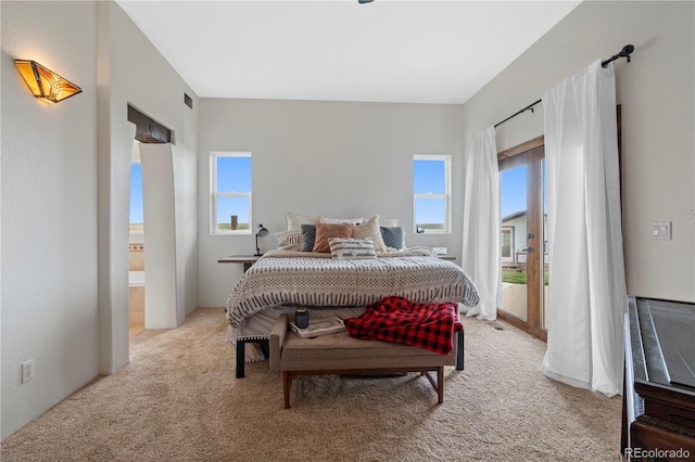 bedroom with access to outside and light colored carpet