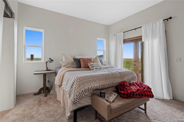 bedroom with light carpet and multiple windows