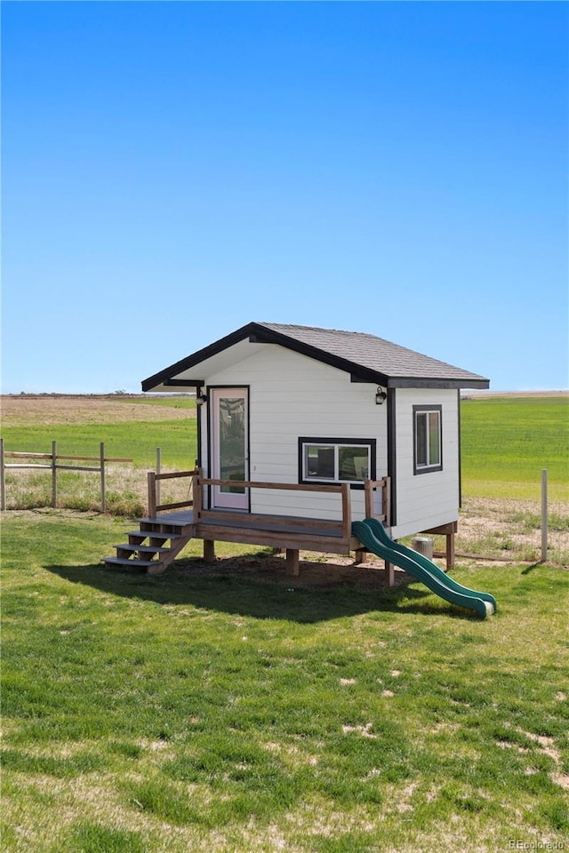 rear view of house with a yard and a rural view