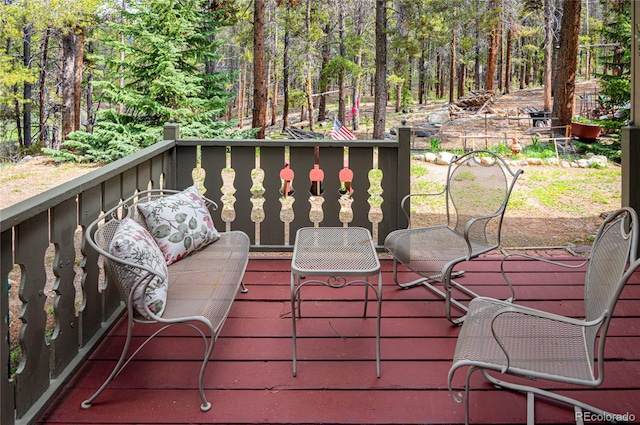 wooden terrace featuring a wooded view