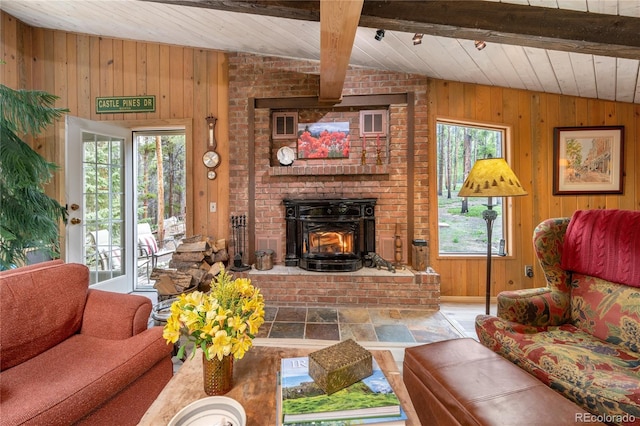 living area with lofted ceiling with beams, stone finish flooring, wood ceiling, and wooden walls