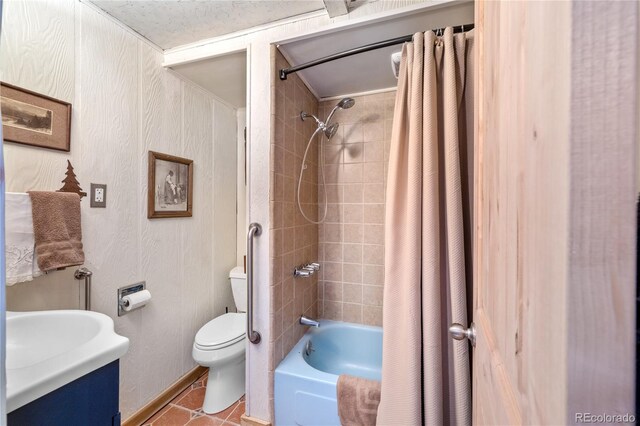 full bathroom featuring tile flooring, a textured ceiling, shower / tub combo with curtain, vanity, and toilet