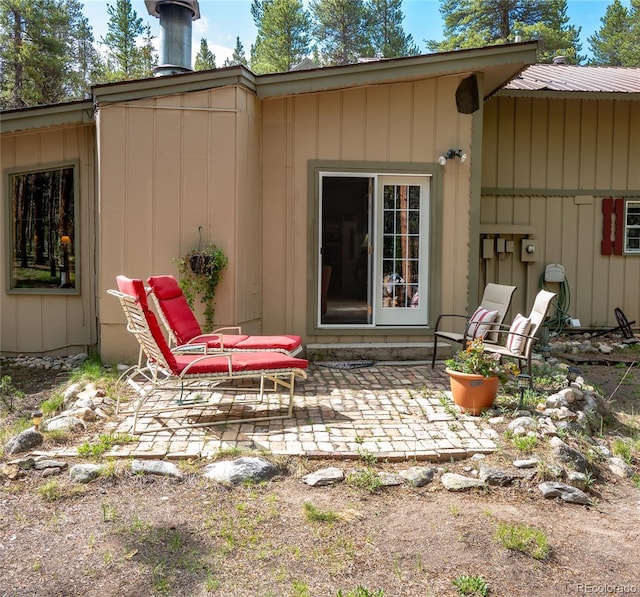 back of property featuring metal roof and a patio area