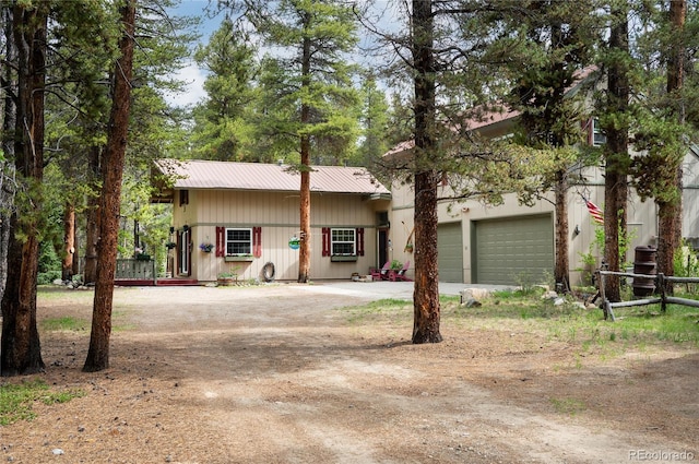 view of front of house featuring metal roof, driveway, and a garage