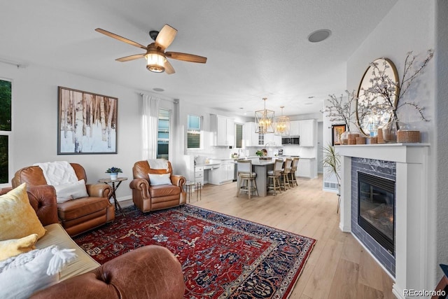 10837 Fox Sedge Way, Highlands Ranch, CO 80126 - living area with a ceiling fan, light wood finished floors, and a glass covered fireplace