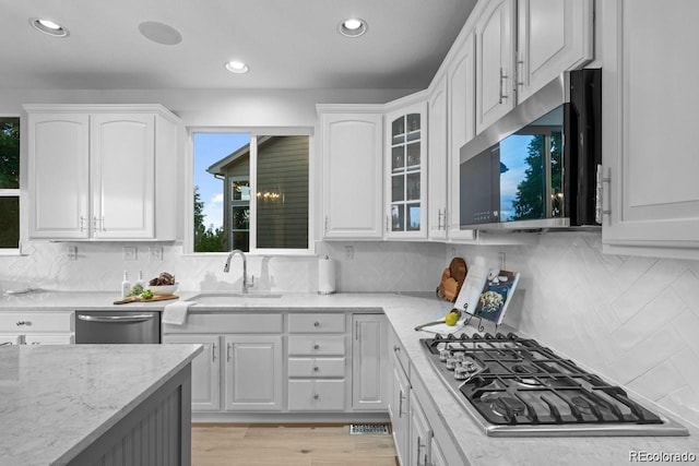 10837 Fox Sedge Way, Highlands Ranch, CO 80126 - kitchen with appliances with stainless steel finishes, light stone counters, white cabinetry, and recessed lighting