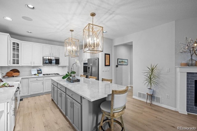 10837 Fox Sedge Way, Highlands Ranch, CO 80126 - kitchen featuring appliances with stainless steel finishes, gray cabinetry, white cabinetry, light wood-type flooring, and recessed lighting