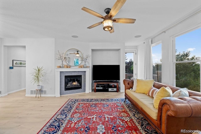 10837 Fox Sedge Way, Highlands Ranch, CO 80126 - living room featuring a ceiling fan, a fireplace, and wood finished floors