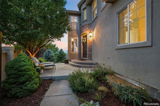 10837 Fox Sedge Way, Highlands Ranch, CO 80126 - exterior entry at dusk featuring stucco siding and stone siding