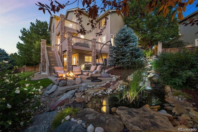 10837 Fox Sedge Way, Highlands Ranch, CO 80126 - rear view of house with an outdoor fire pit, a balcony, stairs, a patio area, and a garden pond
