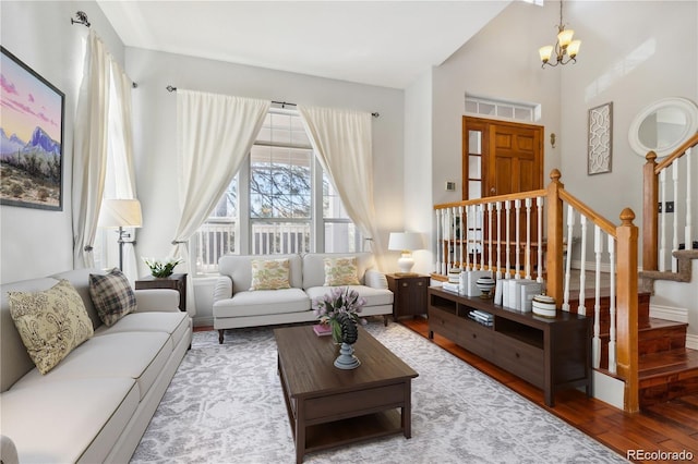 living room featuring hardwood / wood-style flooring, high vaulted ceiling, and a notable chandelier