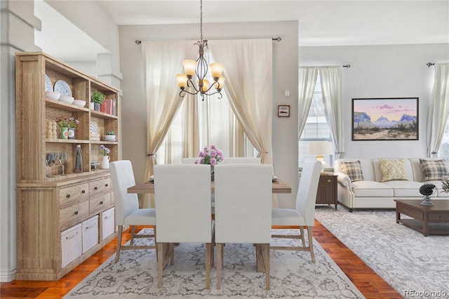 dining space featuring hardwood / wood-style flooring and a notable chandelier