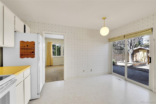 interior space featuring wallpapered walls, light floors, and baseboards