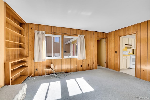 unfurnished room with carpet flooring and wood walls