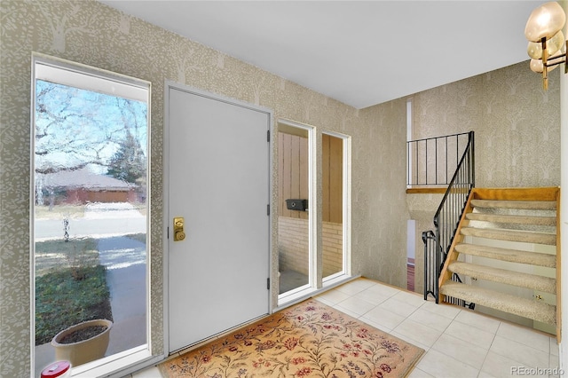 entrance foyer featuring wallpapered walls, tile patterned floors, and stairs