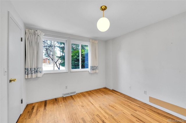 unfurnished room featuring visible vents and wood finished floors