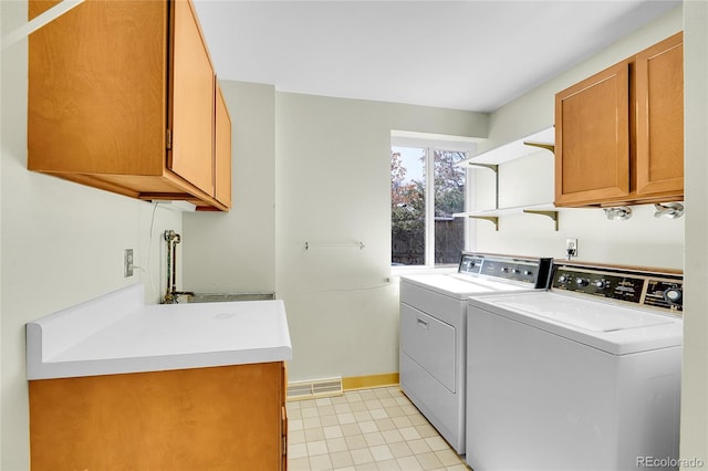 laundry area with washing machine and dryer, cabinet space, baseboards, and visible vents