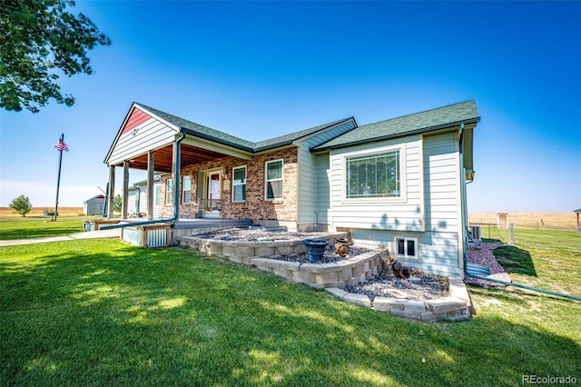 back of property with central AC, a yard, and covered porch