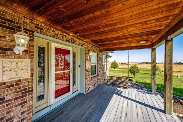 deck featuring covered porch and a yard