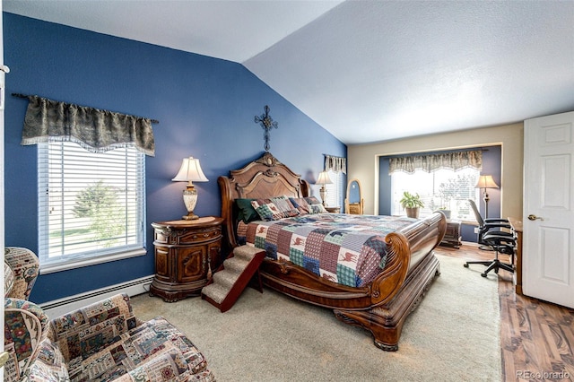 bedroom with hardwood / wood-style flooring, lofted ceiling, and a baseboard heating unit